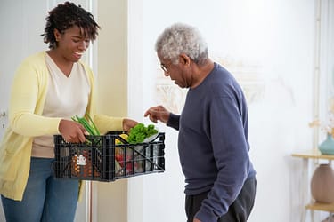 pexels-photo-7551597 a woman holding a plastic crate with fruits and vegetables