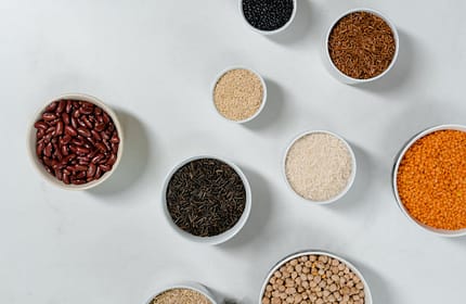 pexels-photo-8108188 Flat lay of diverse grains and legumes in bowls on a marble surface, highlighting healthy ingredients.