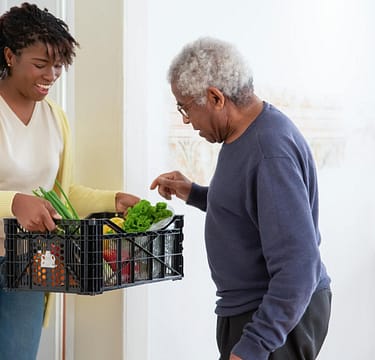 pexels-photo-7551597 a woman holding a plastic crate with fruits and vegetables