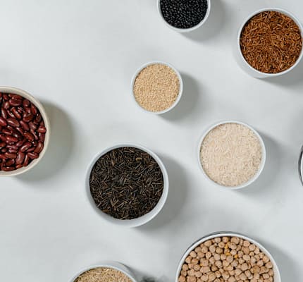 pexels-photo-8108188 Flat lay of diverse grains and legumes in bowls on a marble surface, highlighting healthy ingredients.
